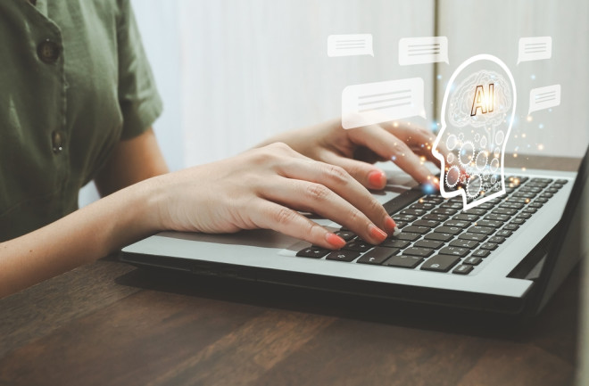 Person typing on a laptop with chatbot icons, representing digital communication 