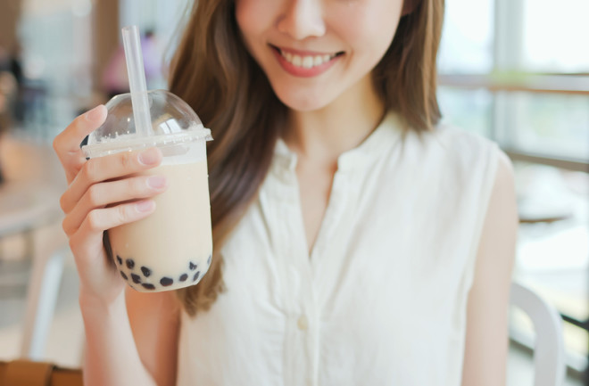 close up of a young woman holding a bubble tea at a restaurant 