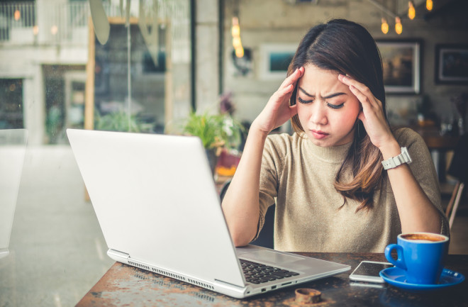 Woman trying to work but she is rubbing her head from Keto Brain Fog