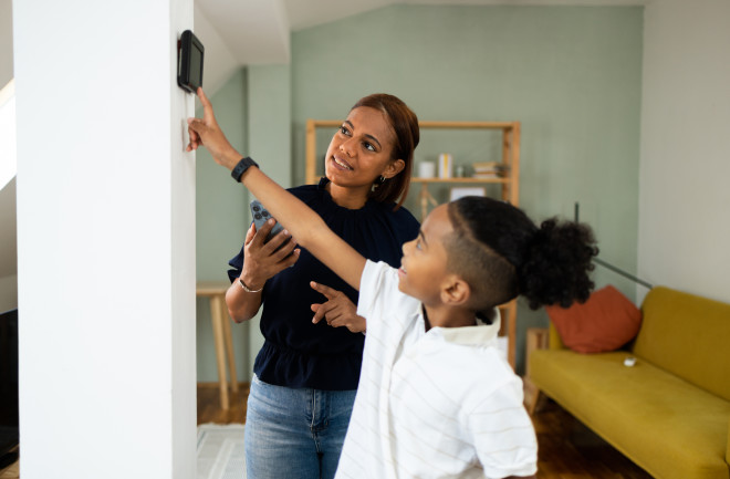 mom-and-child-adjusting-smart-thermostat