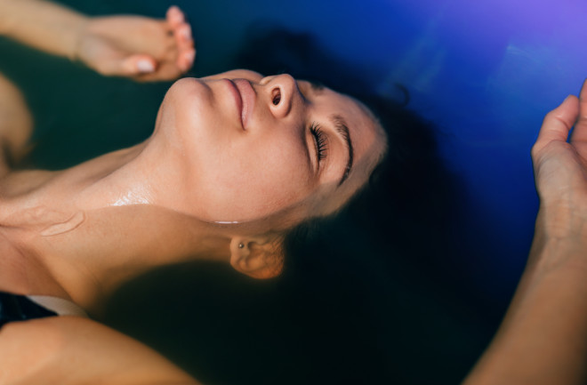 Woman floating in a therapeutic tank for sensory deprivation. 