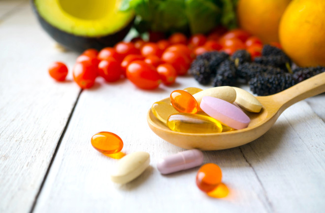 multiple vitamins on a wooden spoon