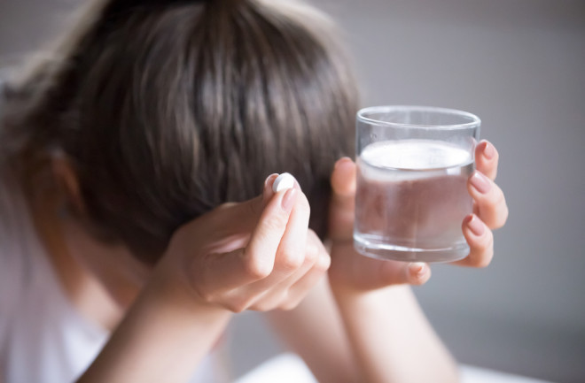 Female taking a pill for a headache