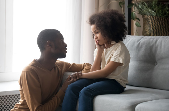 Father comforting child in living room - shutterstock
