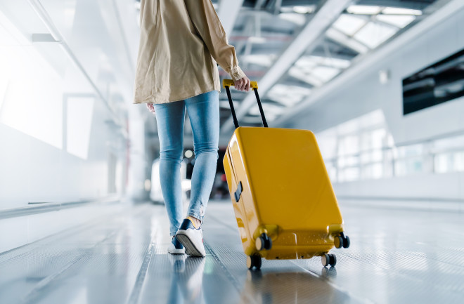 International airport terminal. Beautiful woman with luggage and walking in airport