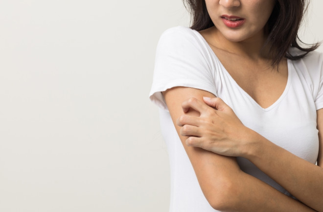 woman scratching an itchy arm